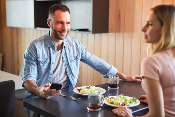 istock Cheerful man enjoying breakfast with lady at home 1307567967