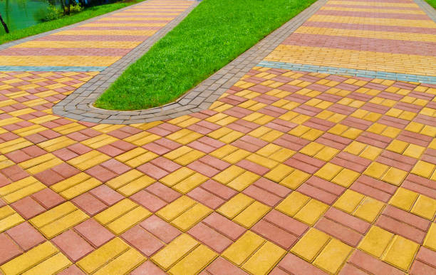 istock walkway made of paving slabs and green grass as a background, bright sunlight 1307568751