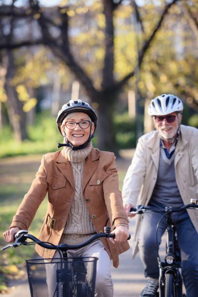 istock Cheerful active senior couple with bicycle in public park together having fun 1307568943