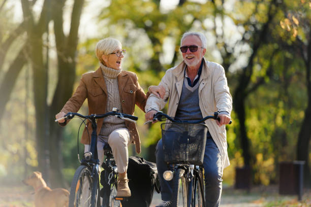 istock Cheerful active senior couple with bicycle in public park together having fun 1307570686