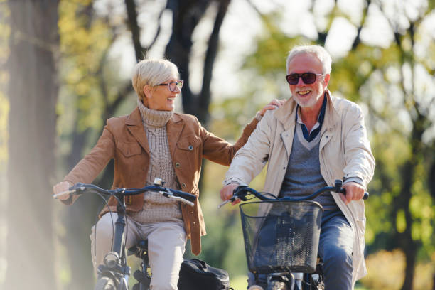 istock Cheerful active senior couple with bicycle in public park together having fun 1307571187