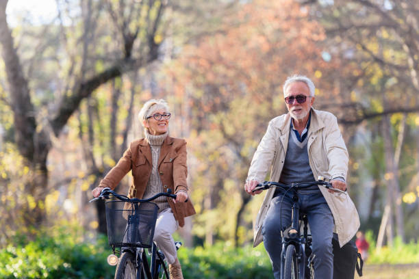 istock Cheerful active senior couple with bicycle in public park together having fun 1307572895