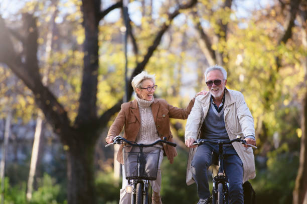 istock Cheerful active senior couple with bicycle in public park together having fun 1307573407