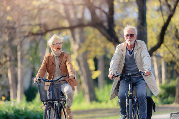 istock Cheerful active senior couple with bicycle in public park together having fun 1307573543