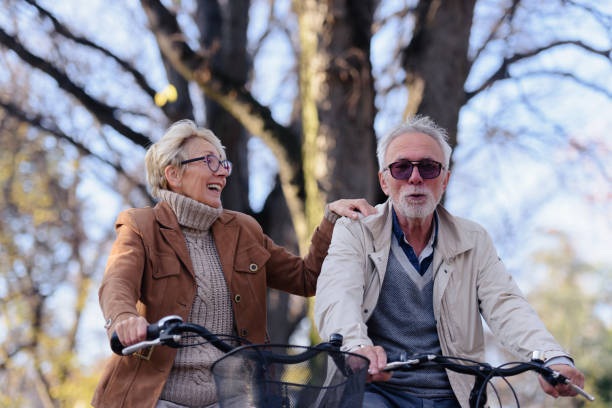 istock Cheerful active senior couple with bicycle in public park together having fun 1307573624
