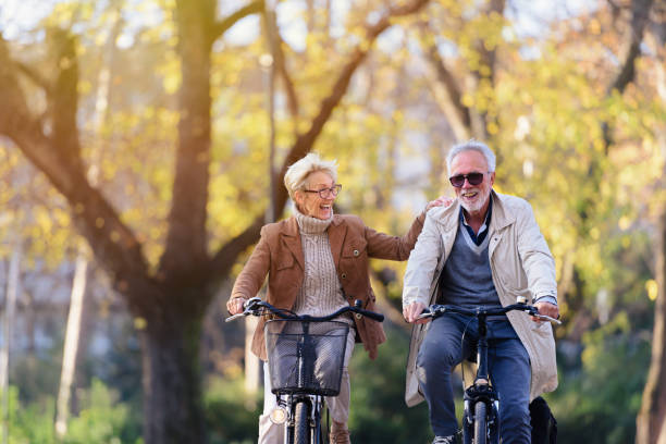 istock Cheerful active senior couple with bicycle in public park together having fun 1307573668