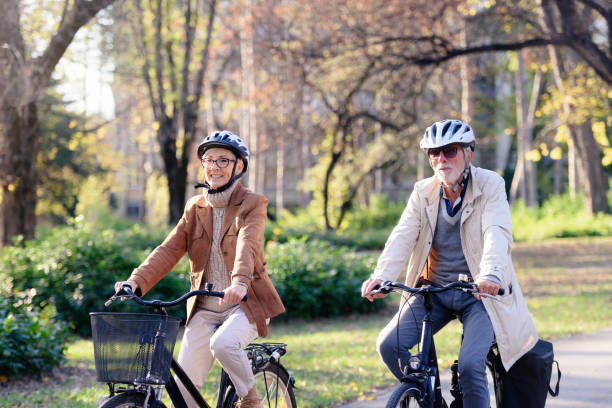 istock Cheerful active senior couple with bicycle in public park together having fun 1307573748