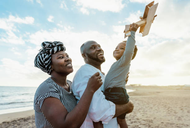 familia africana feliz divirtiéndose en la playa durante las vacaciones de verano - padres amor y concepto de unidad - family beach vacations travel fotografías e imágenes de stock
