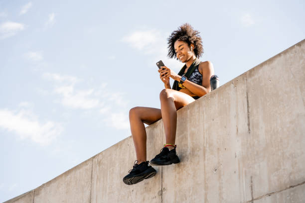 istock Athlete woman using her mobile phone outdoors. 1307578702