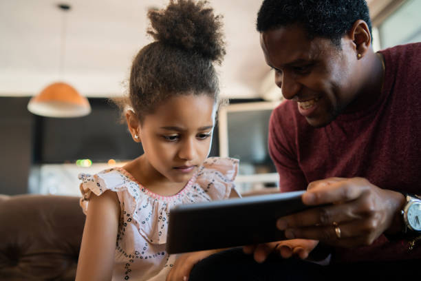 istock Father and daughter using digital tablet at home. 1307578813