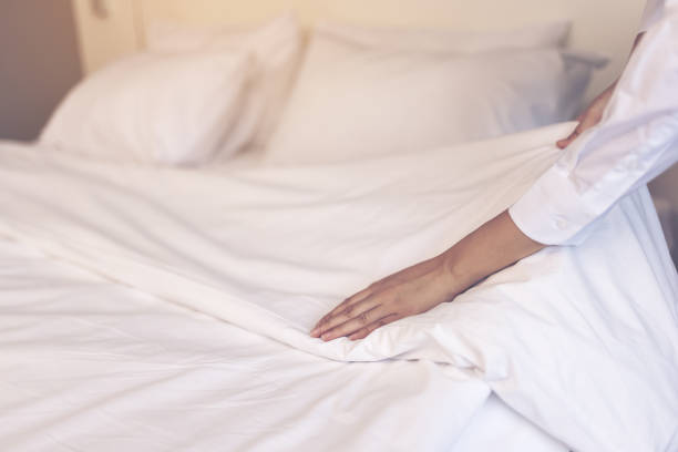 istock Asia maid making bed in hotel room, setting up pillow on bed 1307578834