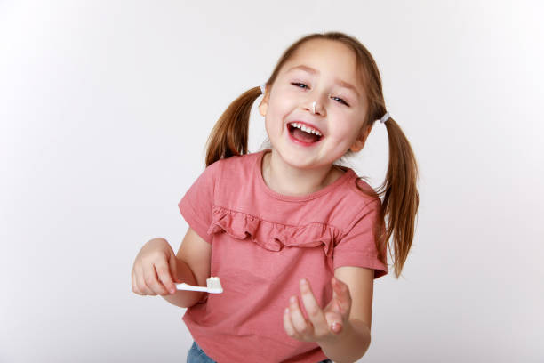 istock Laughing girl with toothpaste and brush 1307582777