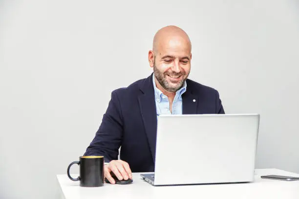 Young businessman sitting at his desk at home working with a laptop. Telework concept. New normality