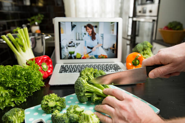 istock Man watching video recipe on laptop and cooking at home. 1307586823