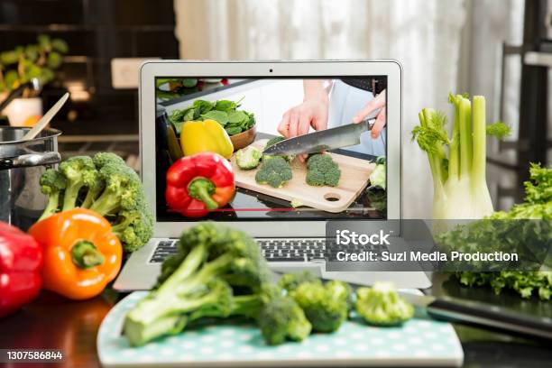 Man Watching Video Recipe On Laptop And Cooking At Home Stock Photo - Download Image Now