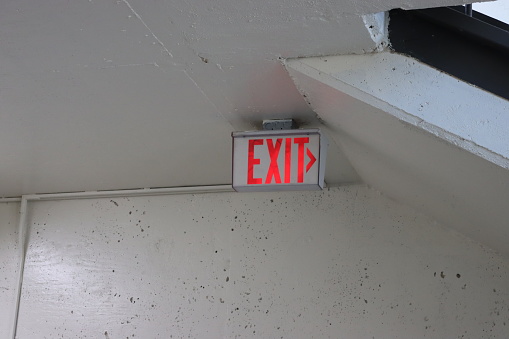 An exit sign in the stairwell of a parking garage