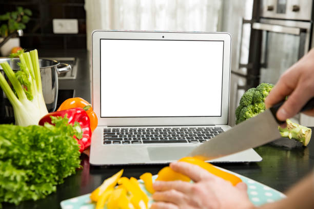 istock Man using laptop and cooking in kitchen at home. 1307586934