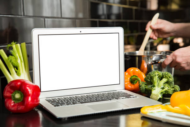 istock Man using laptop and cooking in kitchen at home. 1307586956