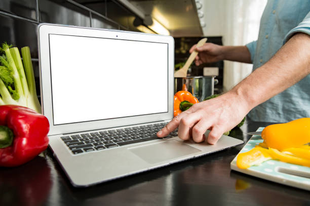 istock Man using laptop and cooking in kitchen at home. 1307587008