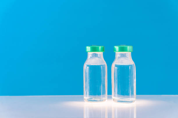 istock Potential trials stage concept on blue background. Close up Vials with sterile needle syringe. Research and Development, Vaccination. 1307587064