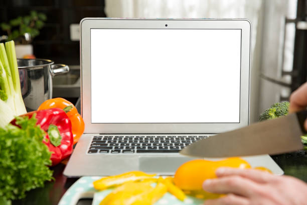 istock Man using laptop and cooking in kitchen at home. 1307587256