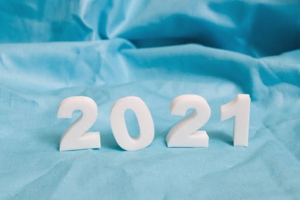 istock Numbers 2021 on blue fabric background close up 1307587976