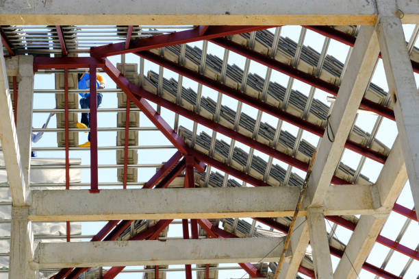 istock Professional team worker service install roof tiles second floor high building dangerous place. Strong metal steel structure paint red color. 1307588799