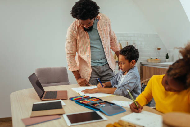 istock Father helping his children with their homework 1307590913