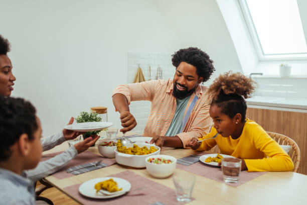 istock Afro family eating lunch together around the kitchen table 1307590930