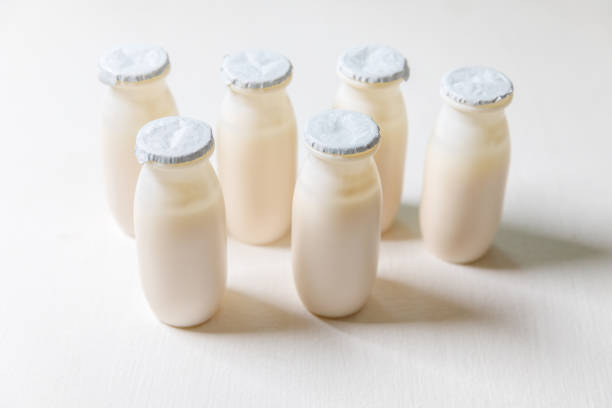 istock Small bottles with probiotics and prebiotics dairy drink on white background. Production with biologically active additives. Fermentation and diet healthy food. Bio yogurt with useful microorganisms 1307592492