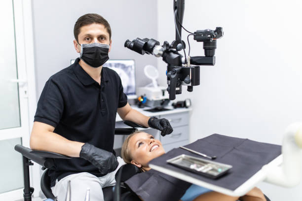 istock Handsome dentist sitting in chair, posing, looking at camera. Dentist man working in private dentistry clinic with modern equipment, professional microscope. 1307594362