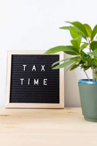 istock Tax time board and potted plant on the table. 1307594439