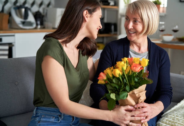 istock Daughter giving her mother flowers 1307595524