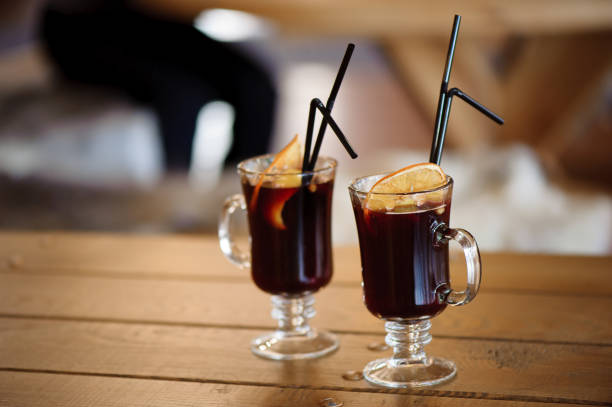 dos vasos con vino caliente y sabroso y caliente sobre una mesa de madera en una cafetería - beer ski apres ski snow fotografías e imágenes de stock