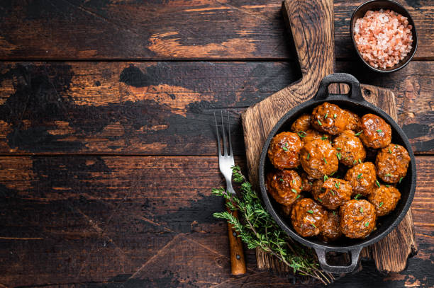 istock Meatballs in tomato sauce from beef and pork meat with thyme in rustic pan. Dark background. Top view. Copy space 1307596743
