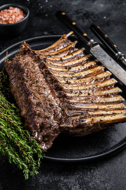 istock BBQ Grilled rack of Lamb mutton Ribs Chops on plate with thyme. Black background. Top view 1307597689