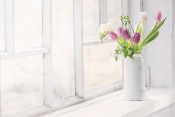 istock beautiful tulips on old white windowsill 1307598465