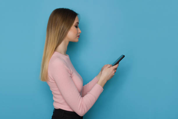 istock Young Woman Is Holding Telephone. Side View. 1307598555