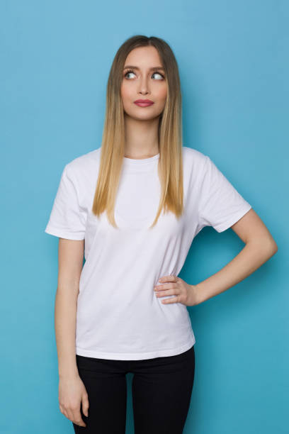 istock Young Woman In White Shirt Is Looking At The Side 1307598556