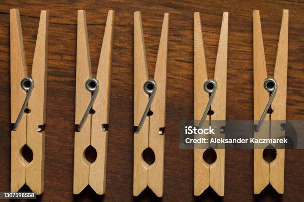 Five Wooden Clothes Pegs On A Brown Dark Table Stock Photo - Download Image Now - Brown, Close-up, Clothespin