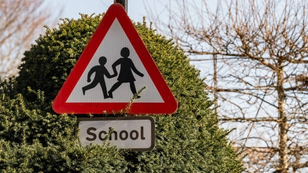 schulkreuzungsschild in einem bebauten gebiet - education sign school crossing sign crossing stock-fotos und bilder