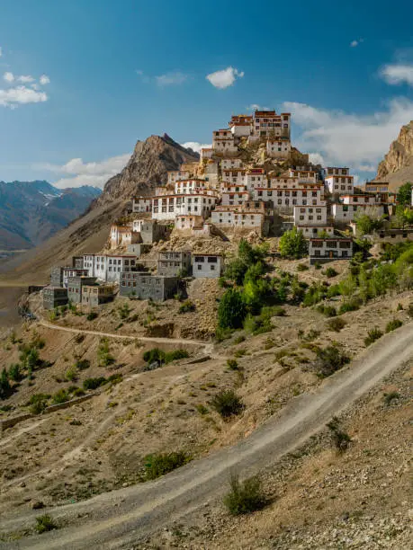 Elevated view of the ancient Key Monastery flanked by the high Himalayas and the Spiti river and valley on a summer's day near Kaza, Himachal Pradesh, India.