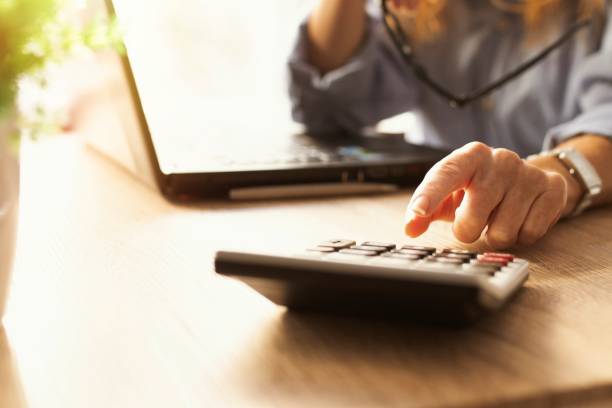 istock business woman hand with calculator and computer on desk 1307603603