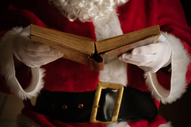 istock santa claus hands with old book 1307603716