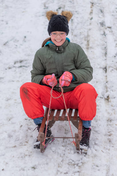 istock Girl On A Sled Playing In The Snow 1307605174