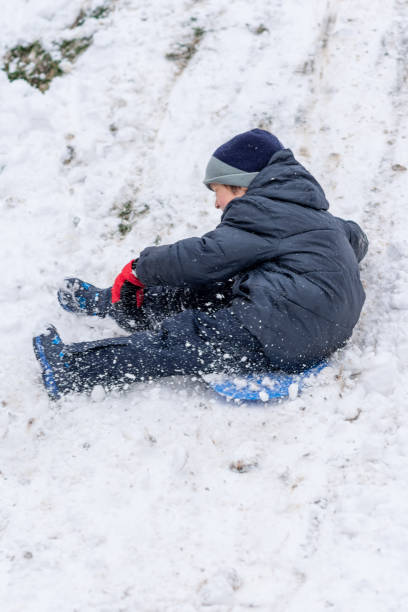 istock Boy On A Plastic Sled Playing on The Snow 1307605269