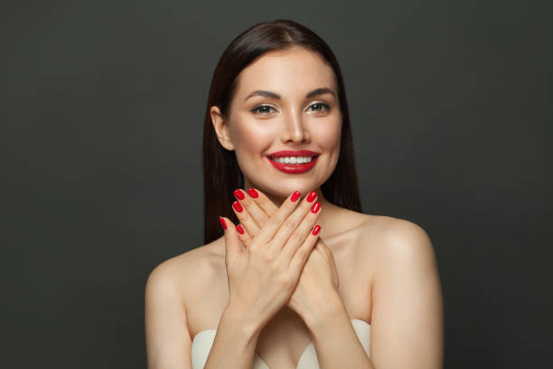 istock Nice woman showing her red manicured nails on black 1307607259