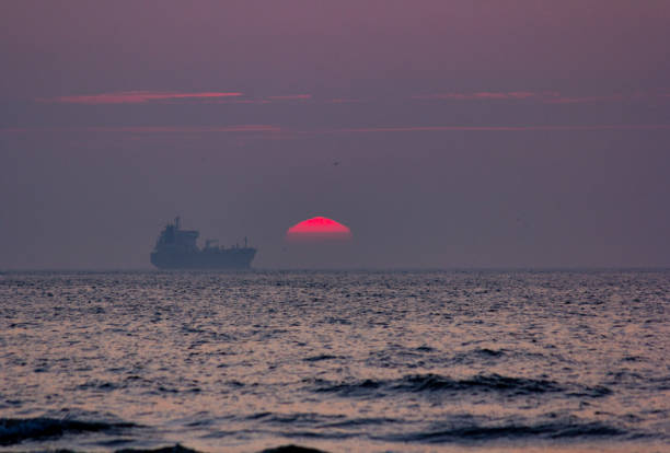 Nave in mare durante il tramonto - foto stock