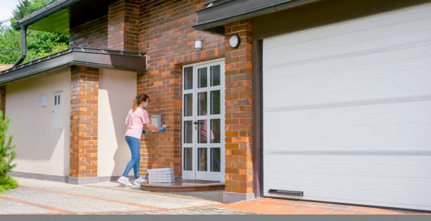 istock Delivery woman dropping off pizza boxes at doorstep 1307608312