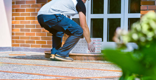 istock Delivery man dropping off pizza boxes at doorstep 1307608330